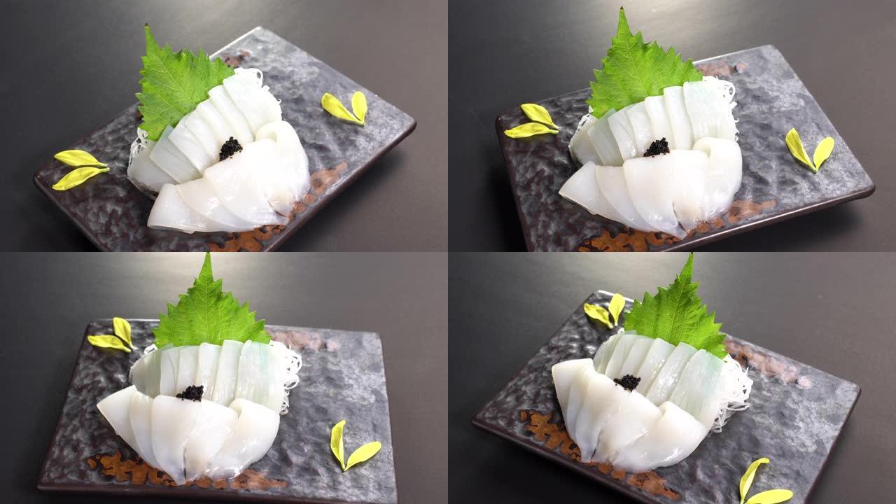 切片日本食物鱿鱼生鱼片晚餐在转盘上。