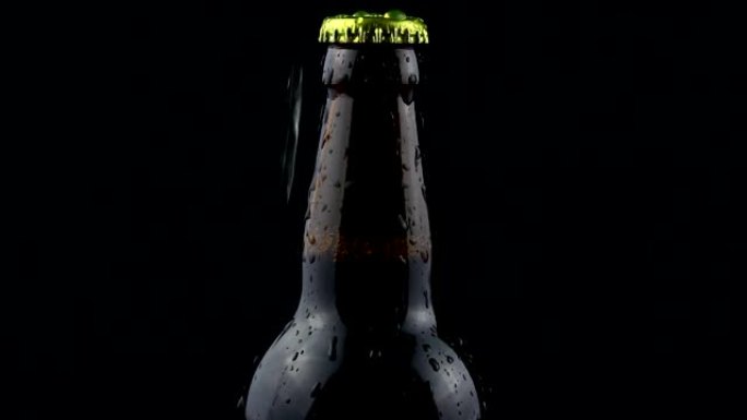在黑暗的背景下，冷凝水滴从啤酒瓶中流下。一瓶迷雾啤酒。