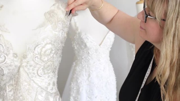 时装设计师在婚纱上进行精致的手工缝制