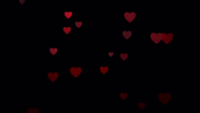 黑色背景上的浮动红心无缝循环，为您的文本复制空间。情人节、母亲节、结婚纪念日的爱、激情和庆祝概念背景