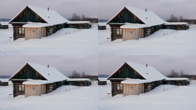 白雪皑皑的松树林中雪覆盖的木屋。冬季景观中的俄罗斯村庄。西伯利亚。4K