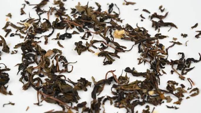 4k关闭干燥的茉莉茶叶掉落在背景上。美丽的干茉莉茶叶特写概念背景。