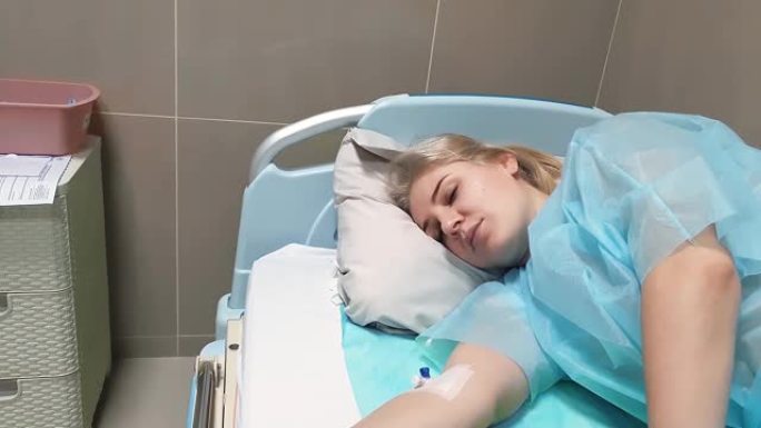 虚弱，瘦弱的年轻女子躺在床上，手臂上的静脉导管