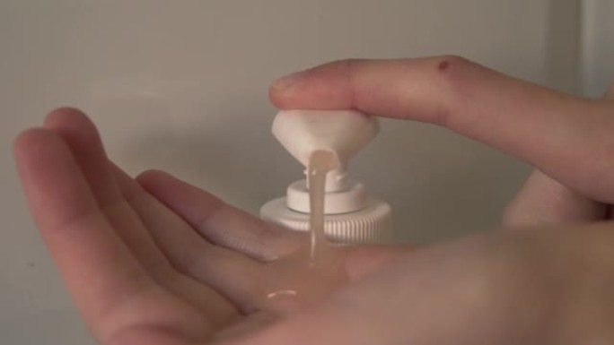 肥皂从皂液分配器喷到孩子的手里。慢动作