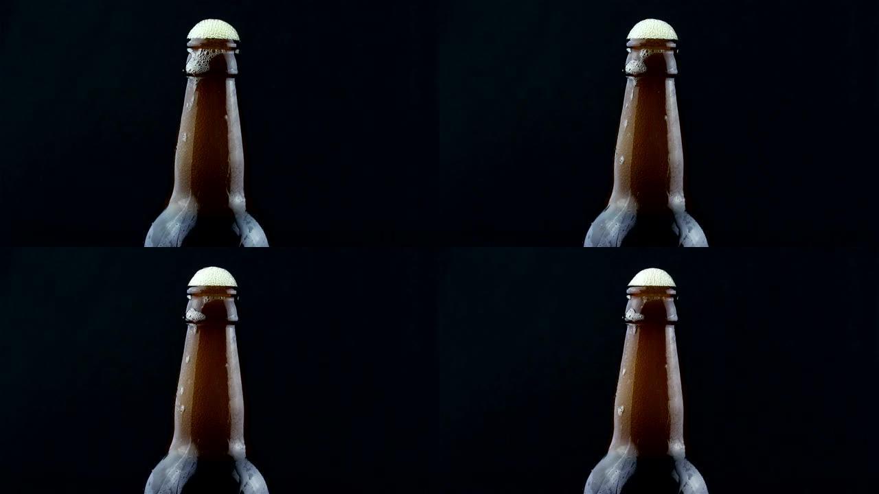 啤酒泡沫从雾状的瓶子里流下来。泡沫从一瓶黑啤酒中流下来。在黑暗的背景上特写一瓶啤酒。
