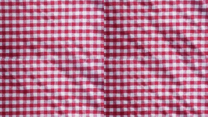 桌布，野餐方格布是平移相机运动。特写微距拍摄方格红红色布料背景。