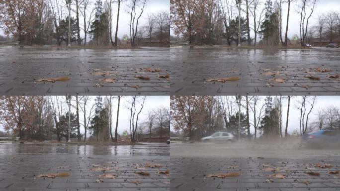 在秋天的雨天，潮湿的道路上的城市交通汽车驶过水坑，车轮飞溅。