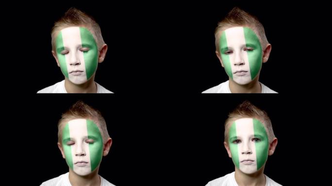 尼日利亚足球队的悲伤球迷。脸上涂着民族色彩的孩子。