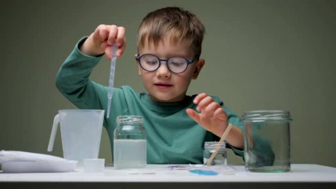 童年科学家在化学实验室学习。男孩，学生在桌子上的科学课上学习和做化学实验，手拿试管。教育理念