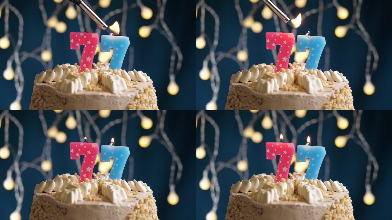 蓝色背景上有77号粉色蜡烛的生日蛋糕。蜡烛着火了。慢动作和特写视图