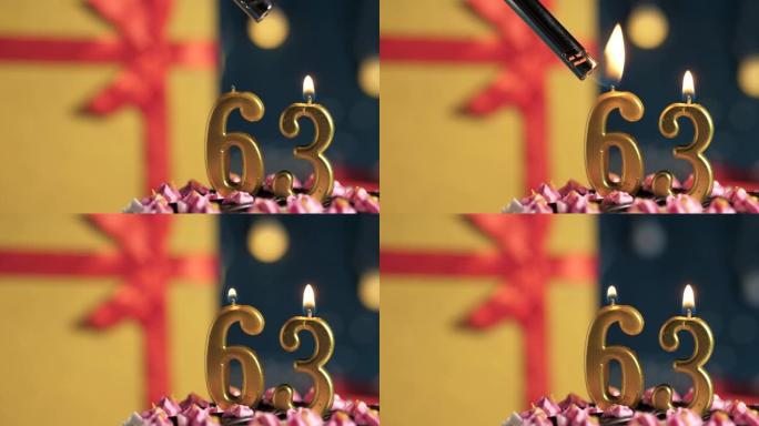生日蛋糕编号63点灯燃烧的金色蜡烛，蓝色背景礼物黄色盒子用红丝带绑起来。特写和慢动作