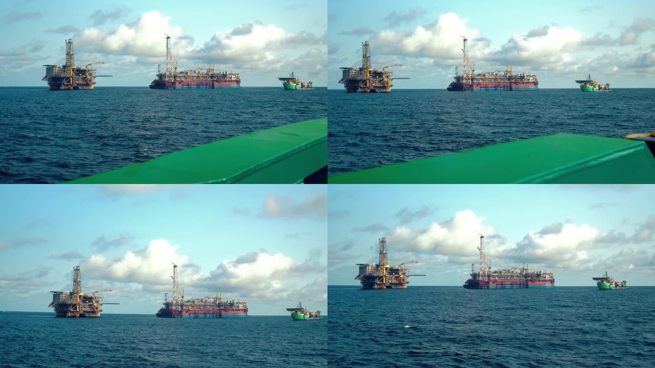 石油钻井平台附近的FPSO油轮。海上石油和天然气工业。火光燃烧着烟雾。从供应船看