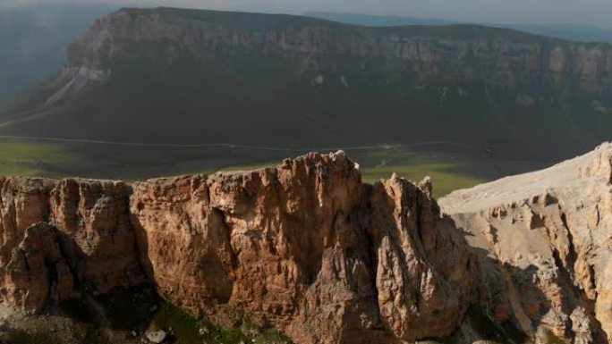 日落时无人机飞越尖锐的岩石露头的鸟瞰图。用于极端登山的陡峭的岩层山。飞行穿越旅行视频