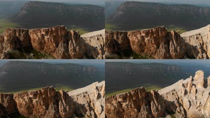 日落时无人机飞越尖锐的岩石露头的鸟瞰图。用于极端登山的陡峭的岩层山。飞行穿越旅行视频