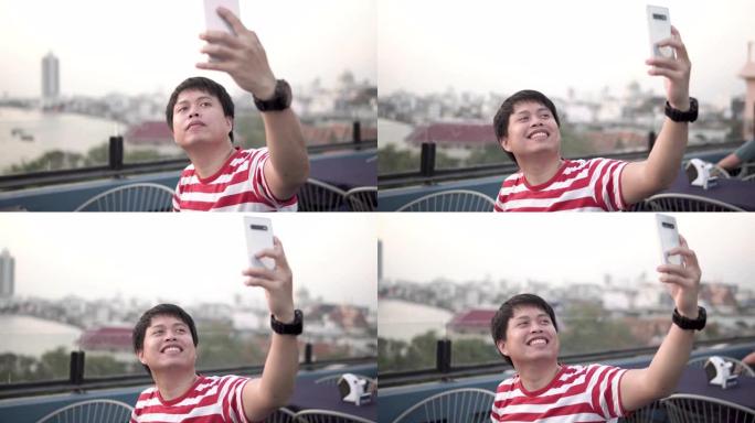 亚洲男子在智能手机上拍照或录像。