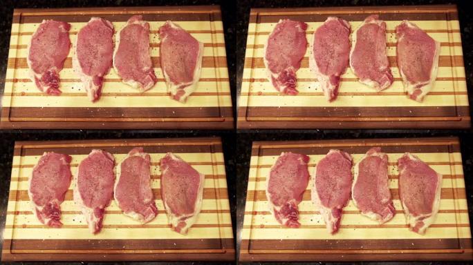 慢动作平放，将新鲜的未煮熟的生去骨里脊肉猪排放在准备烧烤的木制切菜板上