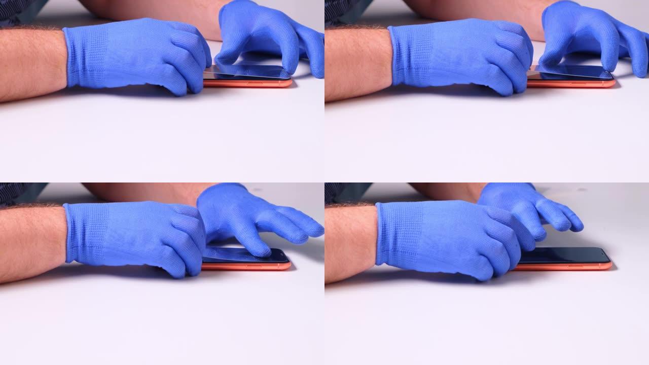 男性手代替了破碎的钢化玻璃屏幕保护膜，用于智能手机。