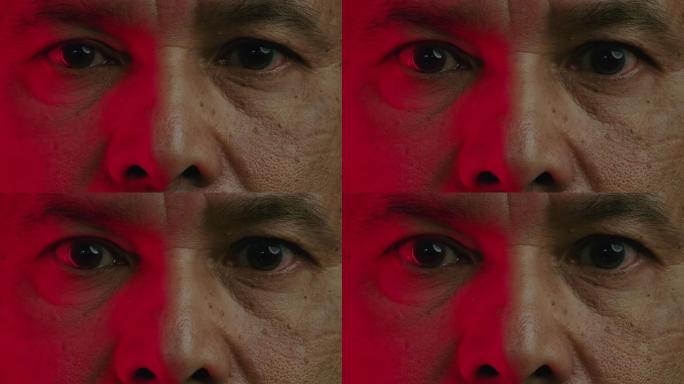 关闭高级男人的眼睛，慢慢睁开眼睛，看着。亚洲男人，用彩色对比的微距拍摄，两只眼睛。红色。