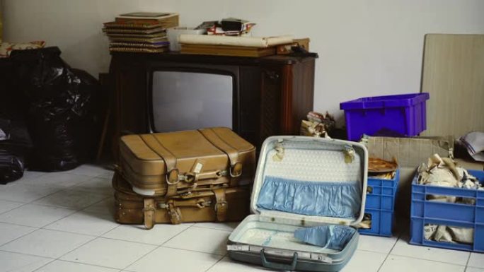 旧的复古电视，二手木制家具，旅行箱，在废弃的扁平房间里包裹了不必要的东西。战时的贫困观念，空荡荡的旧