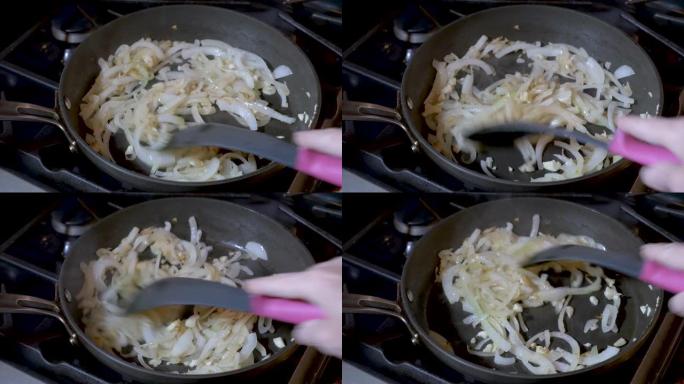 在不粘油的煎锅中手动搅拌洋葱和大蒜
