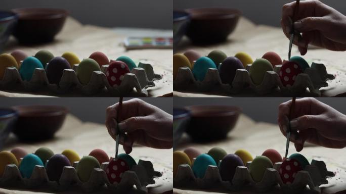 女孩用刷子画五颜六色的鸡蛋。复活节快乐!