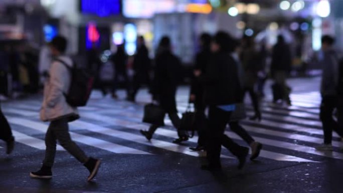 晚上在新宿东京下雨天在十字路口散步的人