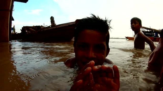 印度小男孩溅到麻烦的水面上另一个孩子在瓦拉纳西码头的背景船上淹没了恒河