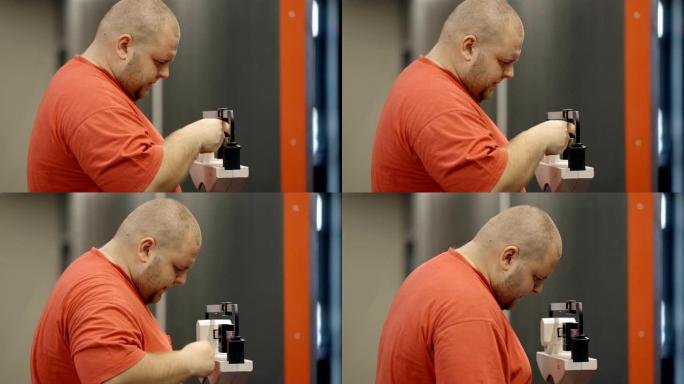 超重男子在健身房训练后站立并使用旧版本的秤进行测量