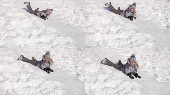 一个孩子在雪山上骑车玩耍。慢动作。白雪皑皑的冬季景观。户外运动