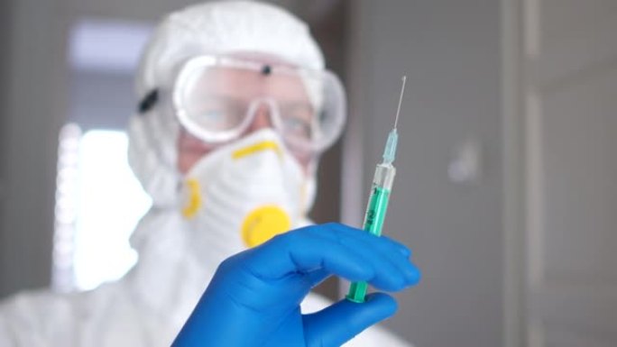 医学研究，冠状病毒疫苗。一名穿着防护服，戴着口罩和呼吸器的男子为患有冠状病毒的患者准备注射