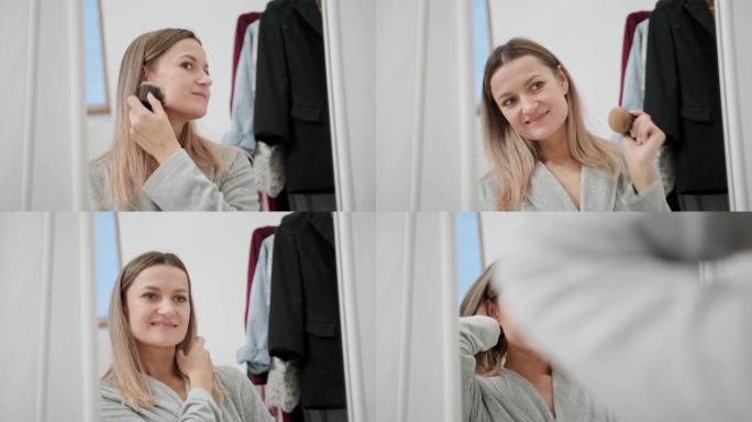一位年轻迷人的千禧一代女性在家里的一面大镜子上化妆。