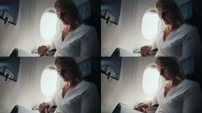 一名中年妇女在飞机上翻阅杂志