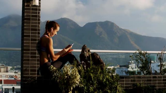 女人在山上的露台上的电话中阅读消息