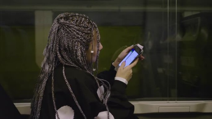 旅行中的女人在火车上使用电话进行社交网络