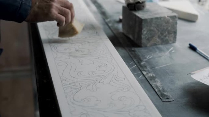 工程师雕刻师在大理石板的表面上涂上清漆