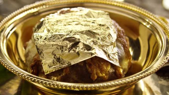 首席炊具把24克拉金片放在肉盘子上。吃黄金覆盖的食物。美味昂贵的金盘子食物。慢动作在红色史诗电影相机
