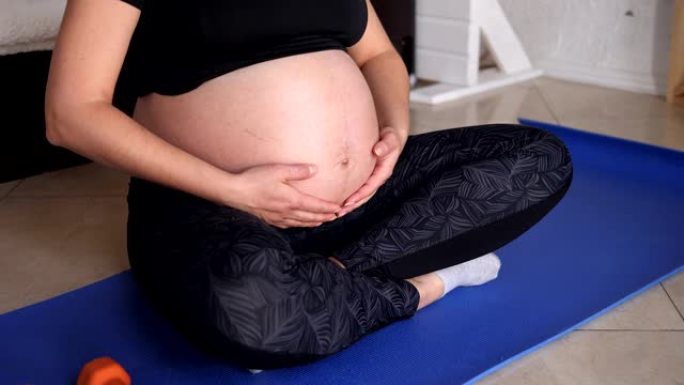 Close-up of pregnant woman doing sports at home, s