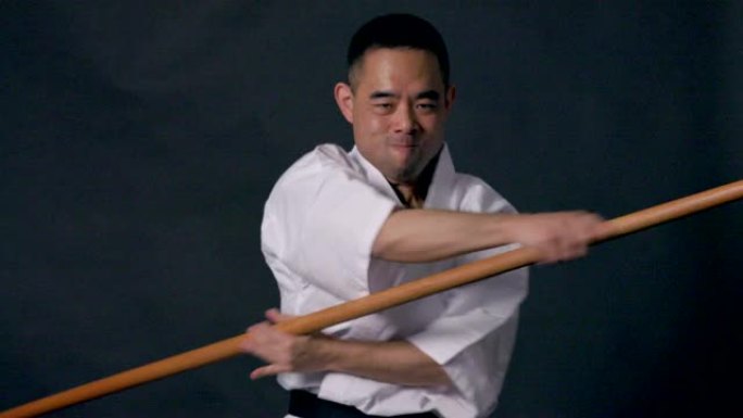 一个穿着和服的男人使用棍棒艺术