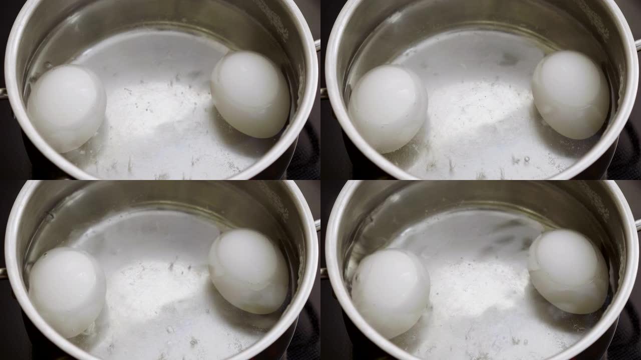在一锅开水中特写两个白鸡蛋。4K