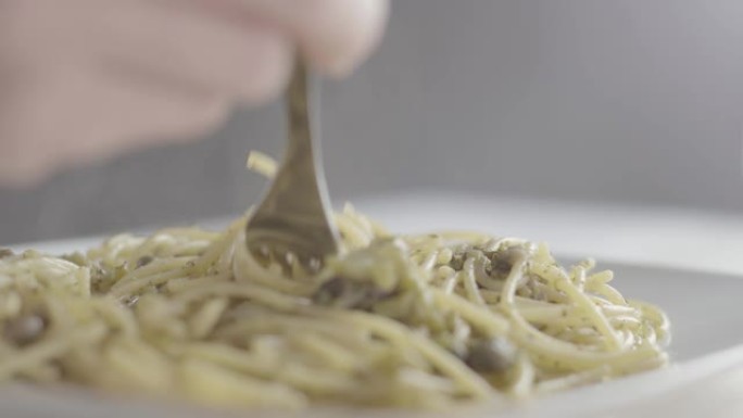 在工作室里，一个意大利女人的手以正确的方式用西兰花和橄榄油卷素食意大利面的特写镜头-4k slog3