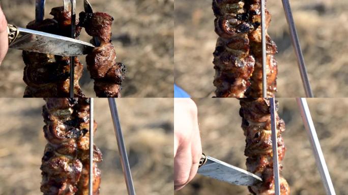 野餐时，用小刀将烤架上的新鲜猪肉烤肉从烤串中取出，放在开阔的天空下的盘子里。高加索户外食物和烧烤概念