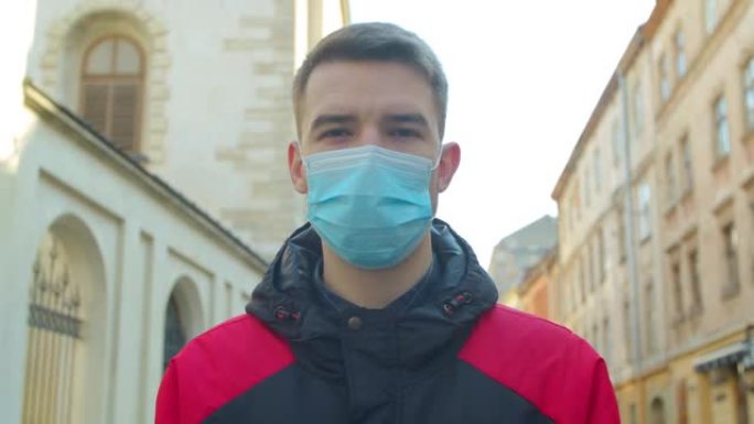 年轻的学生男子在街上戴着防护口罩。健康与安全生命的概念，N1H1冠状病毒，病毒保护。大流行新型冠状病