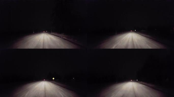 晚上在乡村道路上下雪时，在汽车刹车灯后面行驶。司机的观点POV雪和雪花，在冬天的晚上，车辆在前面