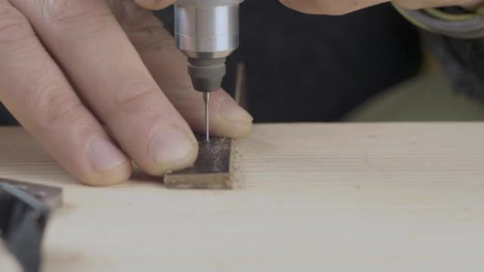 皮革工匠用钻头在皮革表带上钻孔的特写镜头。手工制品。电影院4k视频。C4k