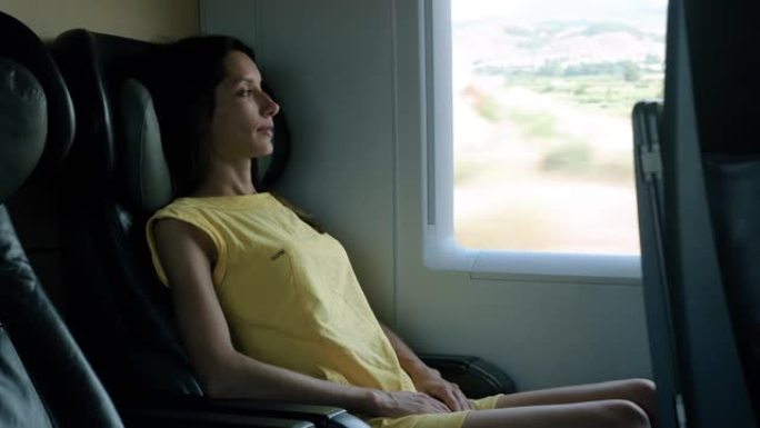 美丽的年轻女子在火车旅行中放松并看着窗外。4K