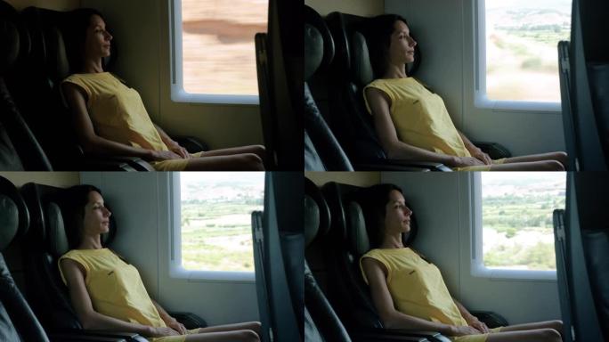 美丽的年轻女子在火车旅行中放松并看着窗外。4K