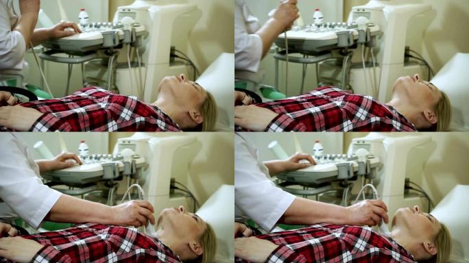 女医生使用超声波扫描仪检查妇女的甲状腺。高清