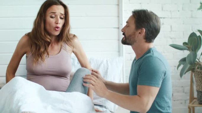 特写镜头让怀孕的妻子在卧室和丈夫争吵。