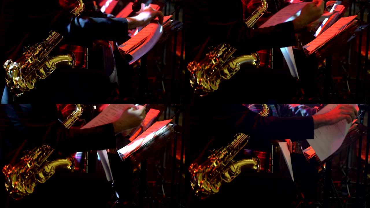 穿着晚礼服的萨克斯演奏家在金色萨克斯管上演奏。现场表演。爵士音乐。