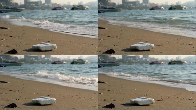 海滩上的泡沫塑料橡胶和废物留在海滩上，海浪将它们吹入海中